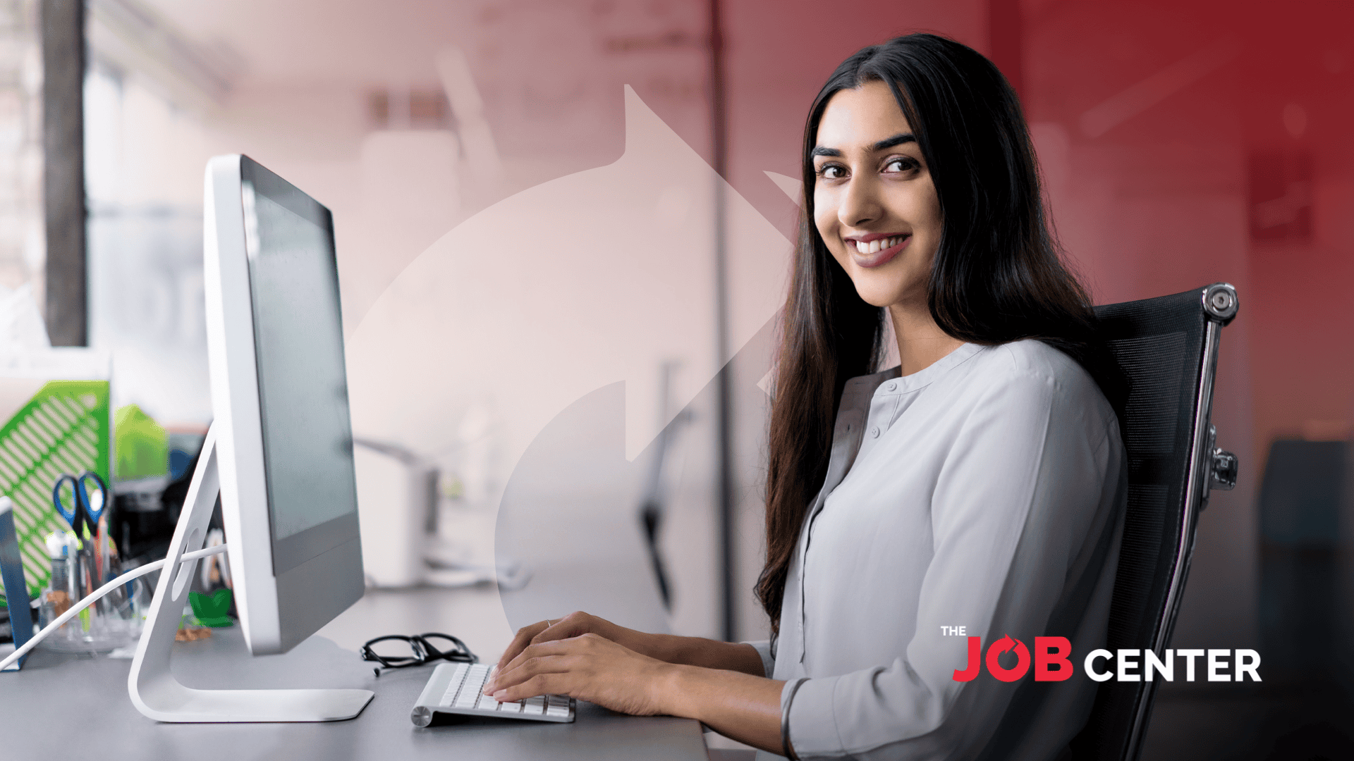 Woman in corporate attire at a long desk speaks to someone, gesturing to printed charts in her hand