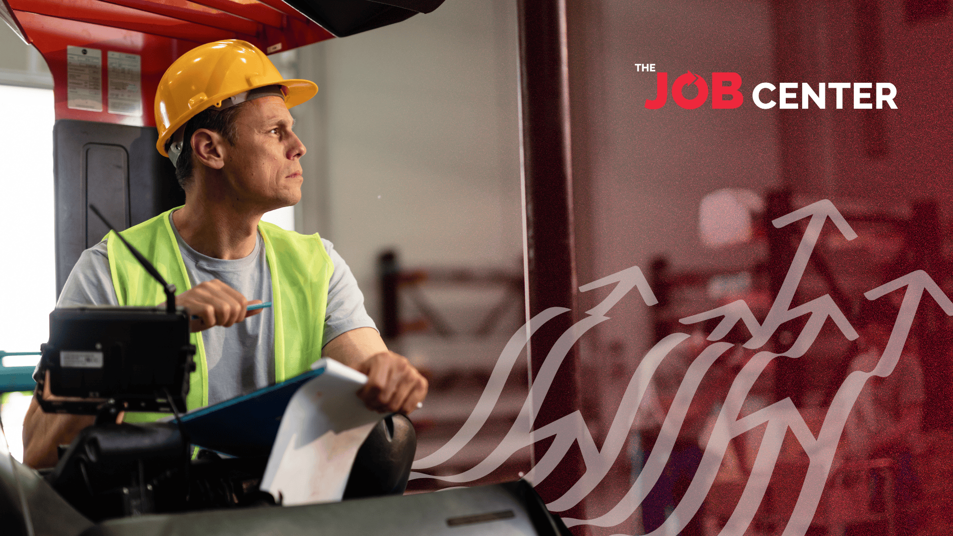 Warehouse worker in safety vest and hard hat operates forklift